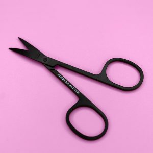 Magnetic eyelash scissors pictured open on a pink background