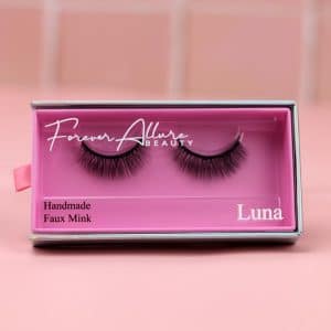 A single set of Luna magnetic lashes on a pink background
